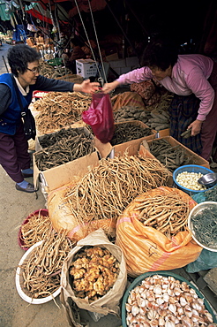 Woman buying ginseng at ginseng and garlic stall, Namdaemun Market, Seoul, South Korea, Asia