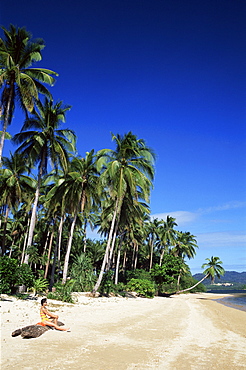 Girl sunbathing on tropical beach, El Nido, Bascuit Bay, Palawan, Philippines, Southeast Asia, Asia