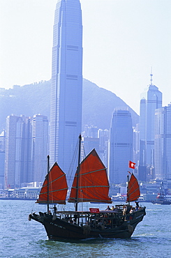 Junk in Victoria Harbour and city skyline, Hong Kong, China, Asia