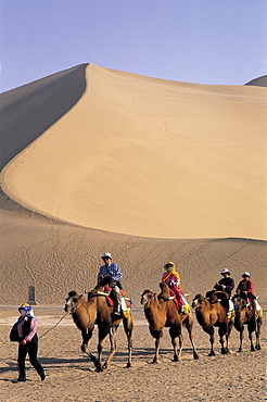 Tourists riding camels at Mount Mingshan, Dunhuang, Gansu Province, China, Asia