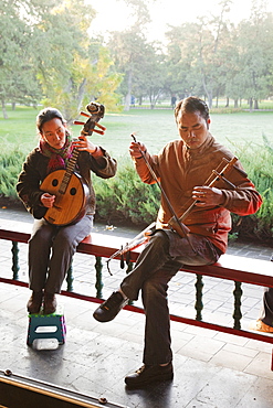 Man and woman playing traditional Chinese stringed instruments, Temple of Heaven Park, Beijing, China, Asia