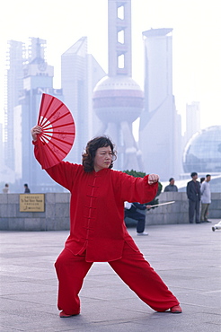 Woman doing martial arts on the Bund, with Pudong skyline in background, Shanghai, China, Asia