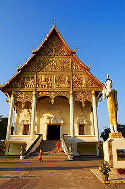 Statue of standing Buddha and monks, Pha That Luang temple, Vientiane, Laos, Indochina, Southeast Asia, Asia