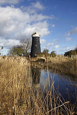 A bright winter day in the Norfolk Broads showing Tall Mill near Upton, Norfolk, England, United Kingdom, Europe