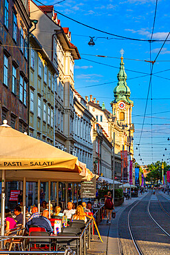 View of Parish Church of the Holy Blood and cafes, Graz, Styria, Austria. Europe