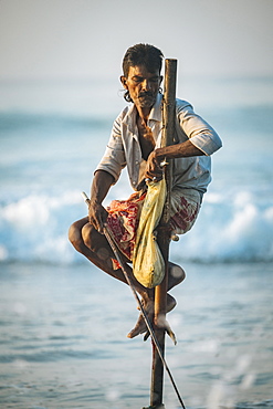 Stilt Fisherman at dawn, Weligama, South Coast, Sri Lanka, Asia