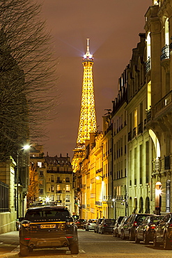 The Eiffel Tower rising above the streets of Paris at night, Paris, France, Europe