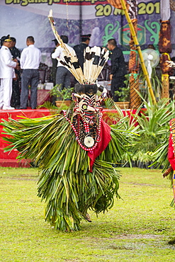 Masqked man wearing feather hornbill during Parade Hudoq