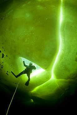 Scuba diver exit the maina (sawed entry hole) to dive under the ice, Arctic circle Dive Center, White Sea, Karelia, northern Russia