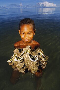 Boy and Giant Clam Fergusson island Papua New Guinea