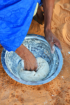 Mauritanian travel guide making a tagella (local bread) at a wood fire at a camp in the desert. Chinguetti. Ancient ksour of Ouadane, Chinguetti, Tichitt and Oualata. Adrar. Mauritania