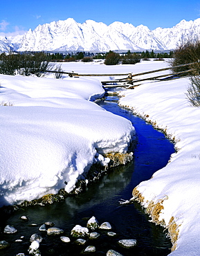 splitrail fence across a stream below the Teton Range in winter Grand Teton National Park Wyoming USA  
