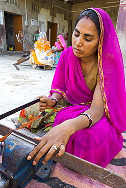 Women constructing solar cookers at the Barefoot College in Tilonia, Rajasthan, India. The Barefoot College is a worldwide charity, founded by Bunker Roy, its aims are, education, drinking water, electrification through solar power, skill development, health, women empowerment and the upliftment of rural people. The use of the cookers, vastly reduces the amount of fire wood women have to go out and collect from the forest.