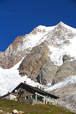 The Refuge E Soldiel below the Aiguille De Tre La Tete in the Italian Alps on the Tour Du Mont Blanc, with the rapidly retreating glaciers of Glacier De La Lex Blanche and  Glacier du Petit Mont Blanc.