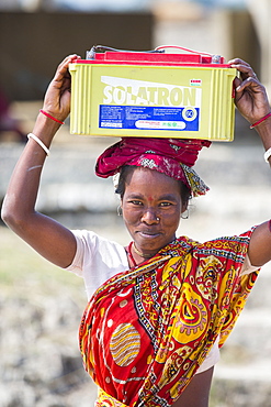 A WWF project to supply electricity to a remote island in the Sunderbans, a low lying area of the Ganges Delta in Eastern India, that is very vulnerable to sea level rise. Prior to this project the subsistence farmers had no access to electricity. The project involves charging large batteries from solar panels. Each villager collects a battery to run household lighting, and returns to the recharging station once a week to recharge their battery. This shot shows women carrying the heavy batteries (20Kg) from the charging station.