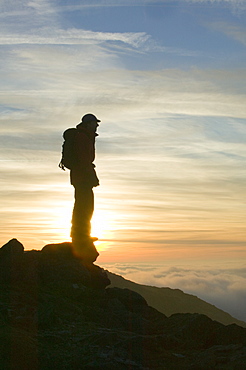 A walker above the clouds on Wet Side Edge in the Lake District National Park, Cumbria, England, United Kingdom, Europe