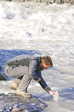 PHD scientist Ian Bartholomew using dye tracing techniques as part of a study to measure the speed of the Russell Glacier near Kangerlussuaq in Greenland, Polar Regions