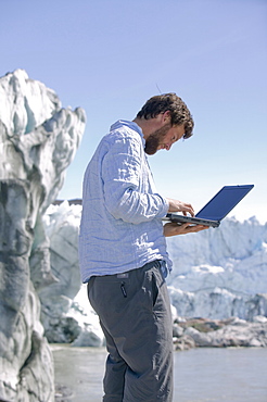 PhD scientist Ian Bartholomew taking measurements as part of a study to measure the speed of the Russell Glacier near Kangerlussuaq, Greenland, Polar Regions