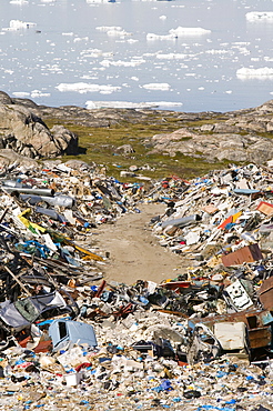 Rubbish dumped on the tundra outside Ilulissat in Greenland with icebergs behind from the Sermeq Kujalleq (Ilulissat Ice fjord), UNESCO World Heritage Site, Greenland, Polar Regions