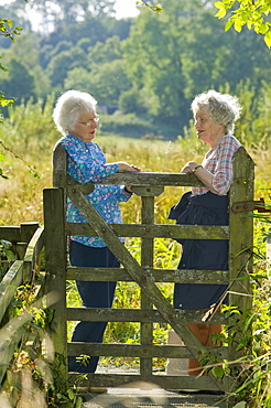 Women chatting over a gate in Ambleside, Lake District, Cumbria, England, United Kingdom, Europe