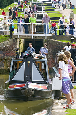 A narrowboat going through Foxton Locks on the Grand Union Canal, the longest series of locks in the UK with visitors on a summer's day, Leicestershire, England, United Kingdom, Europe