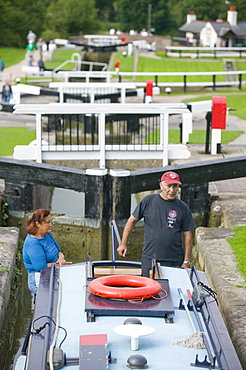 A narrowboat going through Foxton Locks on the Grand Union Canal, the longest series of locks in the UK with visitors on a summer's day, Leicestershire, England, United Kingdom, Europe