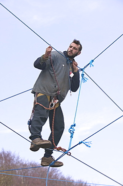 Environmental protestor at the Nine Ladies stone circle camp takes to ropes to avoid bailiffs, Derbyshire, England, United Kingdom, Europe