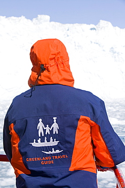 A Greenland tour guide wearing a colourful jacket onboard a ship infront of the Eqi glacier, Greenland, Polar Regions