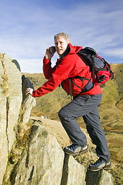 A climber on Red Screes using a mobile phone, Lake District, Cumbria, England, United Kingdom, Europe