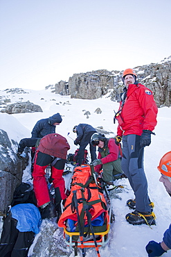 A Navy Sea King helicopter crew and mountain rescue team members treat a seriously injured walker who had fallen 250 , Cumbria, England, United Kingdom, Europe