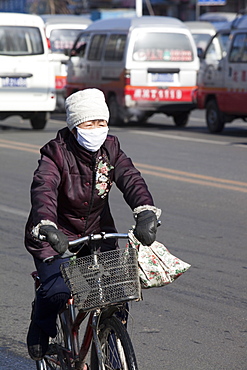 A cyclist wears a face mask against the awful air pollution in Harbin city, Heilongjiang, Northern China, Asia