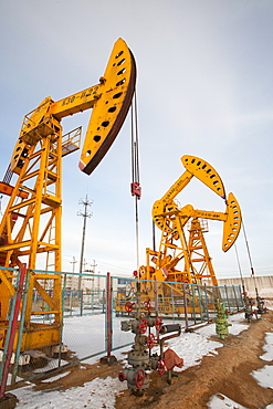 Nodding donkey oil pumps pumping oil up from the Daqing oil field in Northern China, Asia