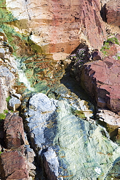 Sea cliffs stained green from copper deposits leaching from the old Geevor Tin Mine near St. Just in Cornwall, England, United Kingdom, Europe