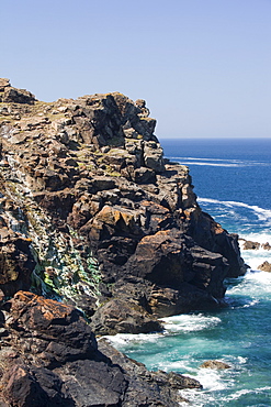 Sea cliffs stained green from copper deposits leaching from the old Geevor Tin Mine near St. Just in Cornwall, England, United Kingdom, Europe