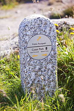 A granite waymarker stone on the South West Coast Path in Cornwall, England, United Kingdom, Europe