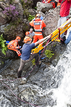 Paramedics from the Great North Air Ambulance and members of Langdale/Ambleside Mountain Rescue Team treat an injured man who fell into Wrynose Beck, before transferring him to hospital via helicopter. Lake District, Cumbria, England, United Kingdom, Europe