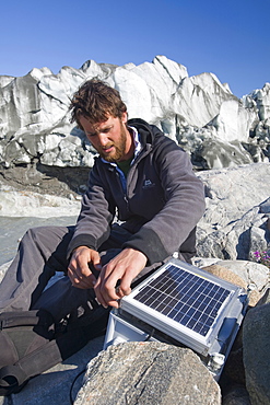 PHD scientist Ian Bartholomew taking measurements as part of a study to measure the speed of the Russell Glacier near Kangerlussuaq, Greenland, Polar Regions