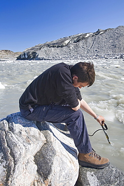 PHD scientist Ian Bartholomew taking measurements as part of a study to measure the speed of the Russell Glacier near Kangerlussuaq, Greenland, Polar Regions