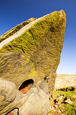 A boulder of millstone grit on Ilkley moor with a perfect circular hole probably formed by a large inclusion weathered out of the bedrock, West Yorkshire, England, United Kingdom, Europe