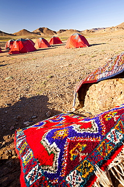 Berber Moroccan woven cloth rugs and bags in front of a trekking campsite in the Anti Atlas mountains of Morocco, North Africa, Africa