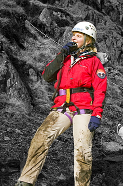 A female member of a mountain rescue team on the radio, Lake District, Cumbria, England, United Kingdom, Europe