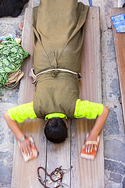 A woman prostrating herself at the Boudhanath Stupa, one of the holiest Buddhist sites in Kathmandu, Nepal, Asia