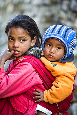 A young Nepalese girl with her baby brother in the Himalayas, Nepal, Asia