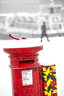 A post box in heavy snow at Ambleside Pier, Waterhead on Lake Windermere, Lake District, Cumbria, England, United Kingdom, Europe