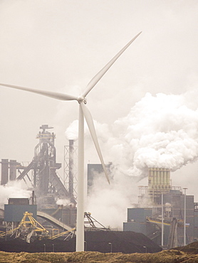 Climate change heaven and hell, emissions from a Tata steel works in Ijmuiden, with a wind turbine, Netherlands, Europe