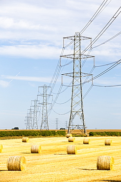 Wheat stubble in a field on Yorkshire's East Coast, UK, with high voltage power lines from a coal fired power station.