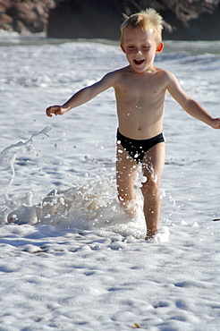 Boy running at water's edge, West Dale