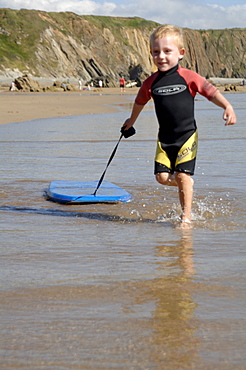 Boy playing in sea with boogie board      (rr)