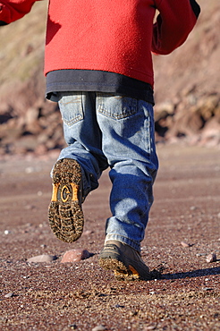 Boy running on West Dale beach, Pembrokeshire, Wales, UK