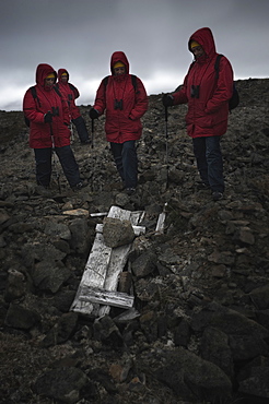 Whalebone Alley, female tourist standing around still intact extremly old inuit elder grave, skeleton still present. Itygran Island (Bering Sea) Russia, Asia.  MORE INFO: Whale Bone Alley was discovered by Soviet archaeologists in 1976, but has remained untouched since and little is known of this place. There is a long double line of bowhead whale bones -- jaws and ribs -- running parallel along the shore for hundreds of yards. Many of the bones, especially the enormous jaw bones, are still standing, propped up by lichen-covered rocks. The location is thought to have been used in about 1300 as a ceremonial site, for a men's secret society or feasting site.